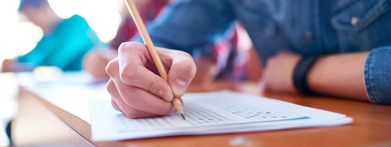 A person taking a test using a pencil.